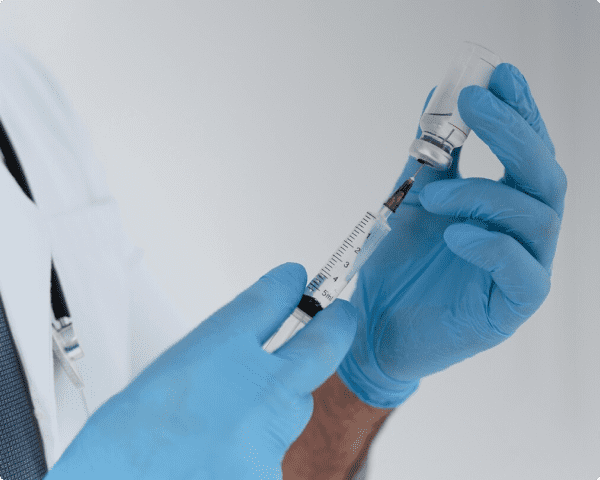 Врач вводит лекарство в шприц